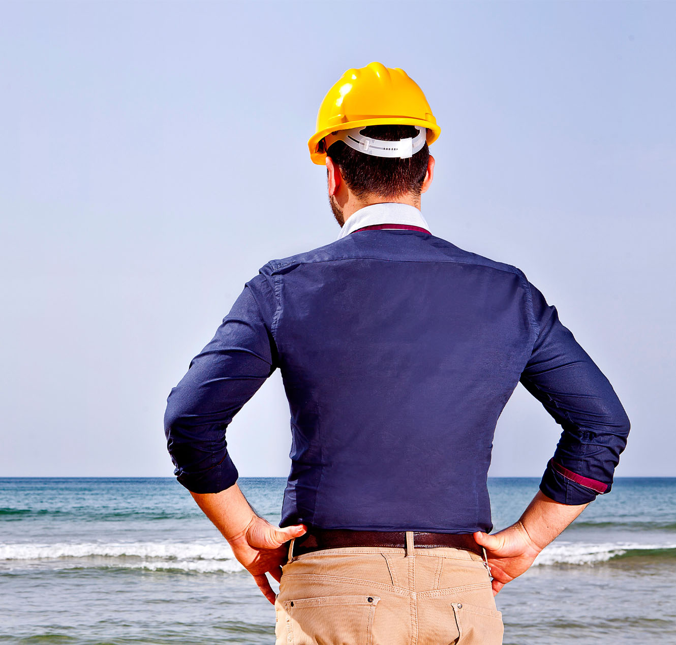 Man in yellow cap standing near sea