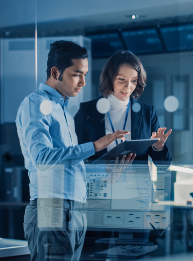 In Technology Research Facility: Female Project Manager Talks With Chief Engineer, they Consult Tablet Computer.
